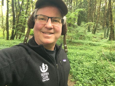 Trees, forests, and man wearing Sierra Club jacket, hat, and glasses