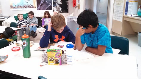 Students working on various projects throughout a classroom. 