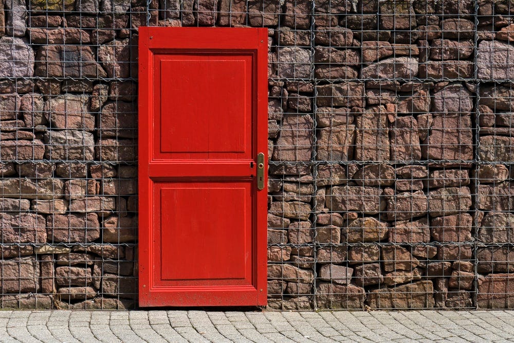 red 2-panel door on black metal chain link board