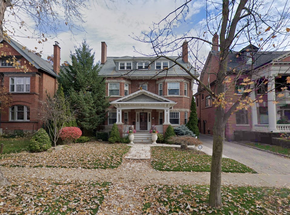 A very nice three-story red brick Victorian house.