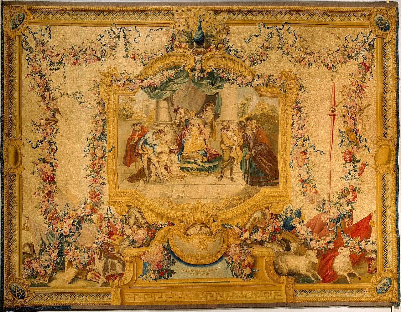 A Gobelins tapestry with Sancho Panza judging a case at the center, inside a wide gold and floral border A Gobelins tapestry with Sancho Panza judging a case at the center, inside a wide gold and floral border