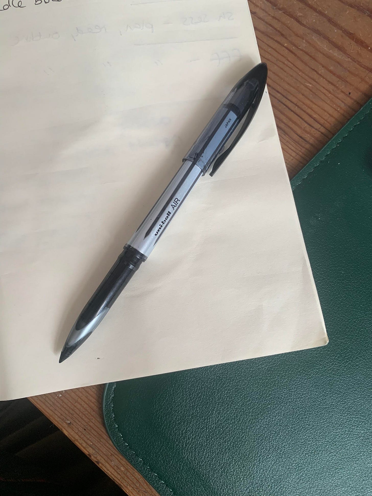A photo of a uniball air pen on a notebook A photo of a uniball air pen on a notebook