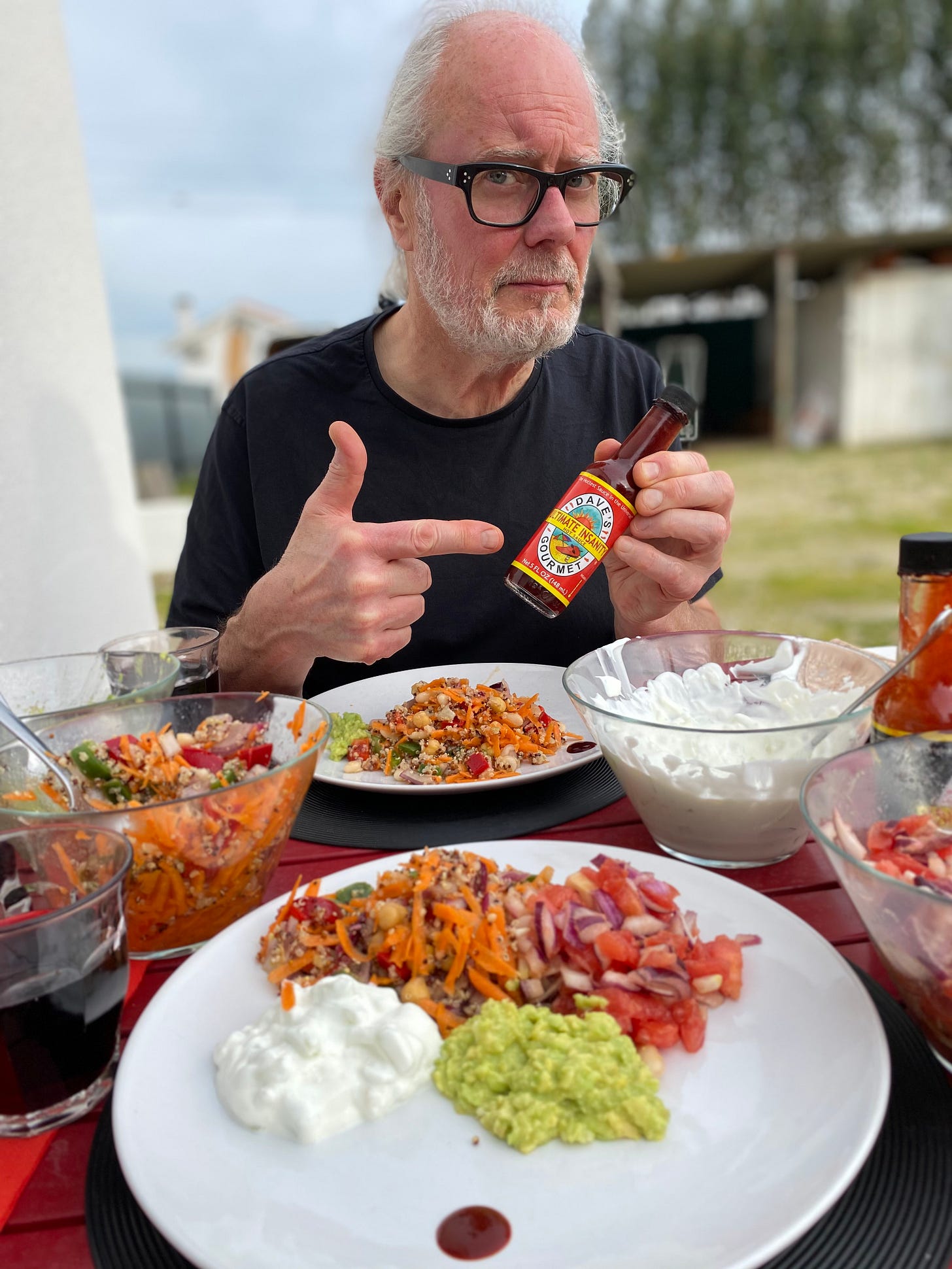 Simon Campbell fooling around with bottle of Dave’s Ultimate Insanity sauce which eating lunch