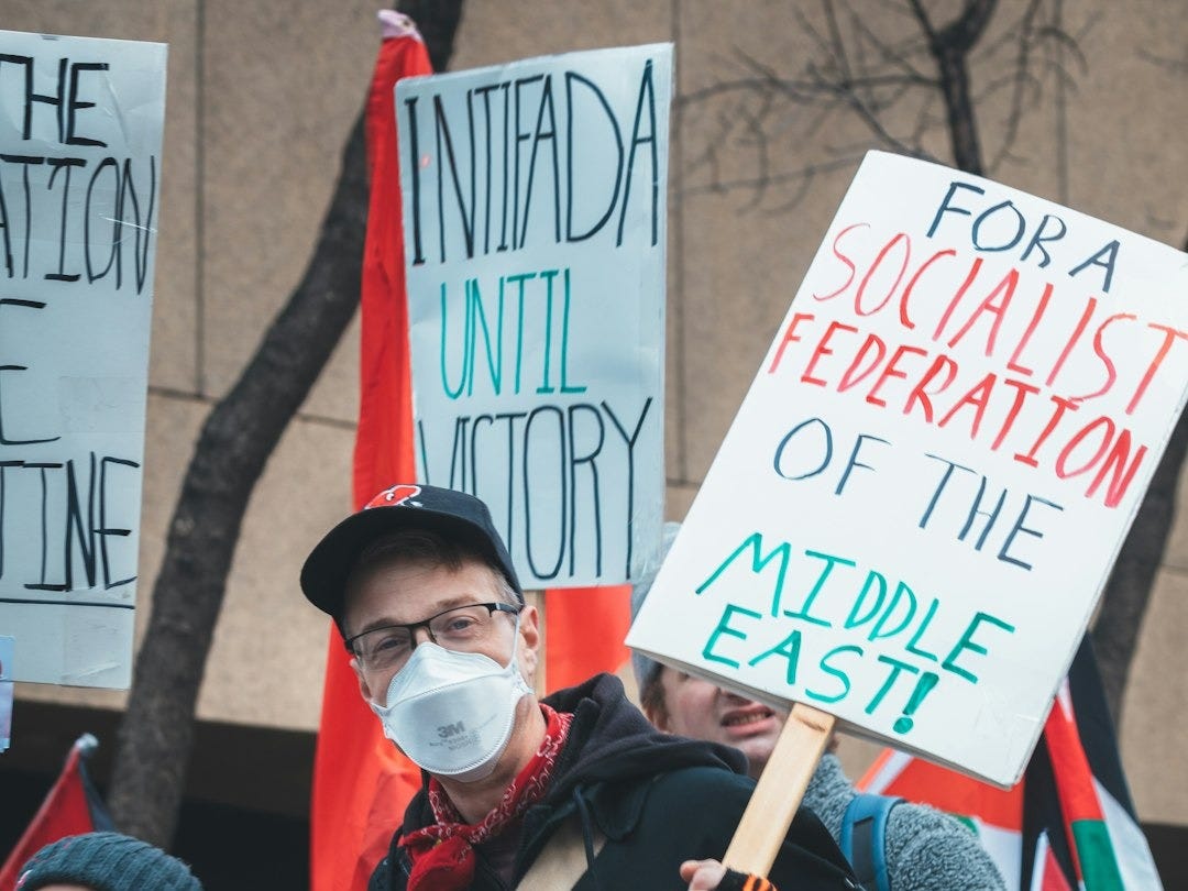 a group of people holding protest signs in front of a building