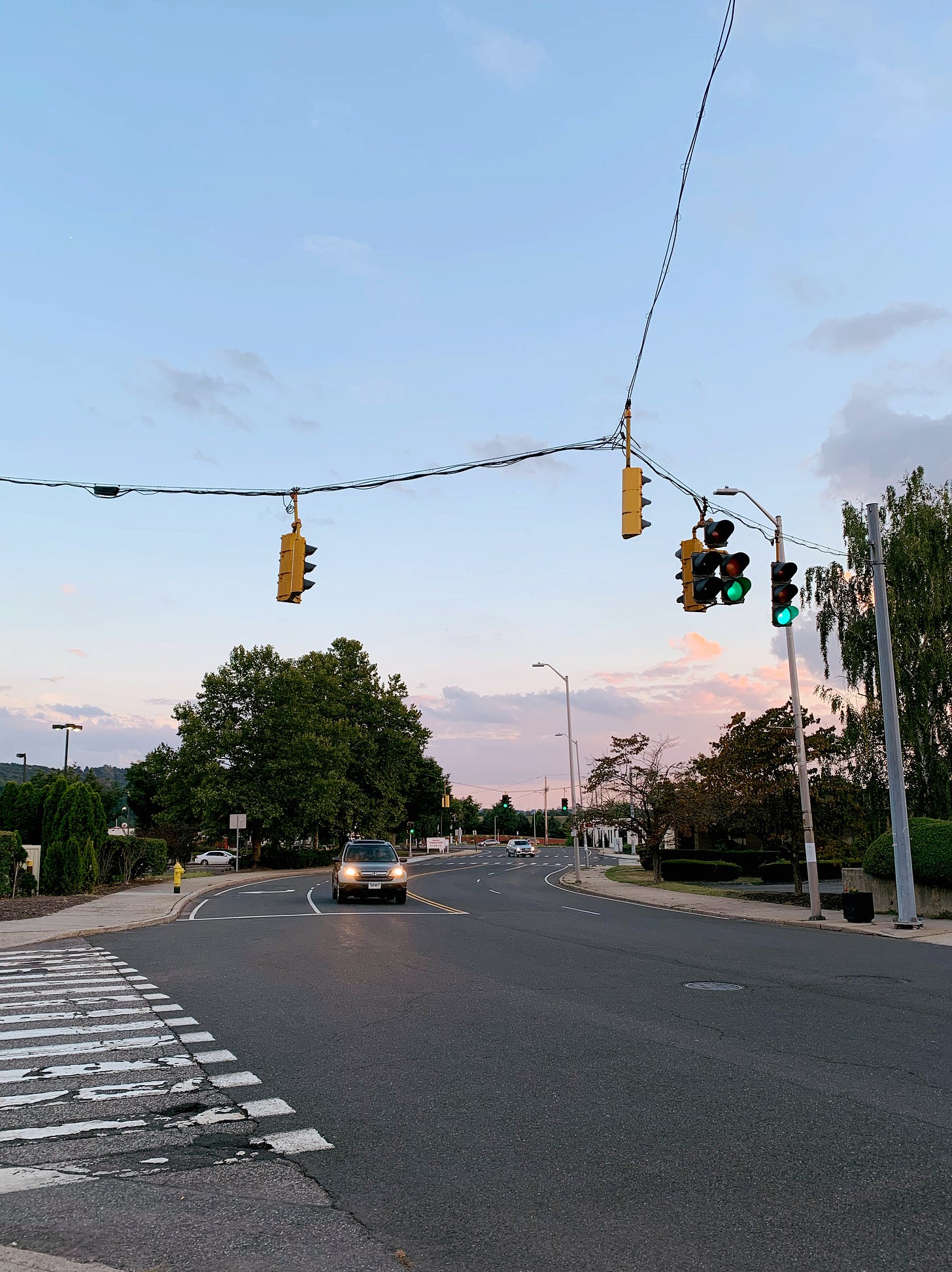 Main street ends in a wide crossing followed by parking lots and department stores