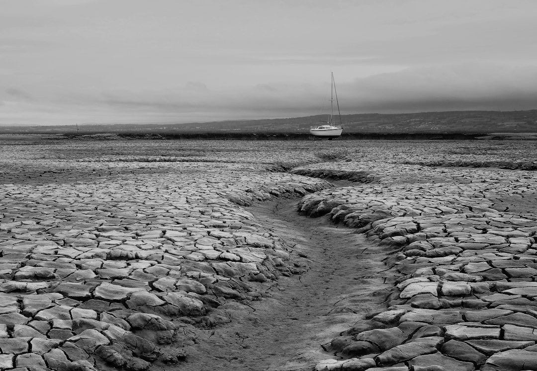 grayscale photo of water on sand