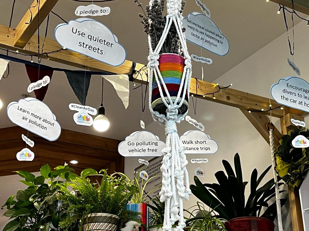 Photo of a display with cut out clouds with messages such as 'Go polluting vehicle free'
