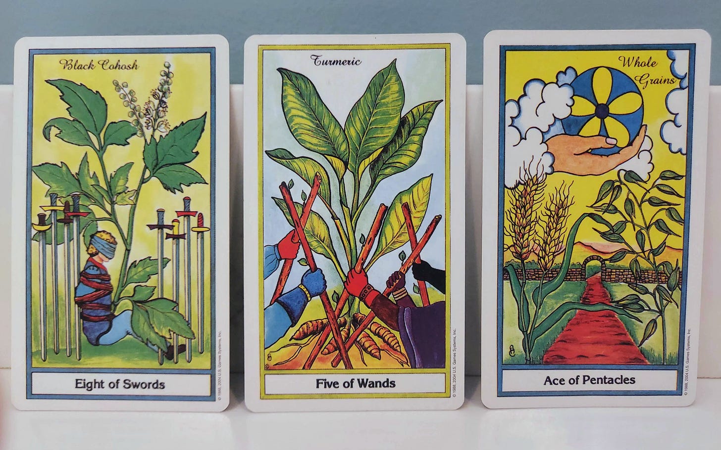 Eight of swords, five of wands, and ace of pentacles from the Herbal Tarot