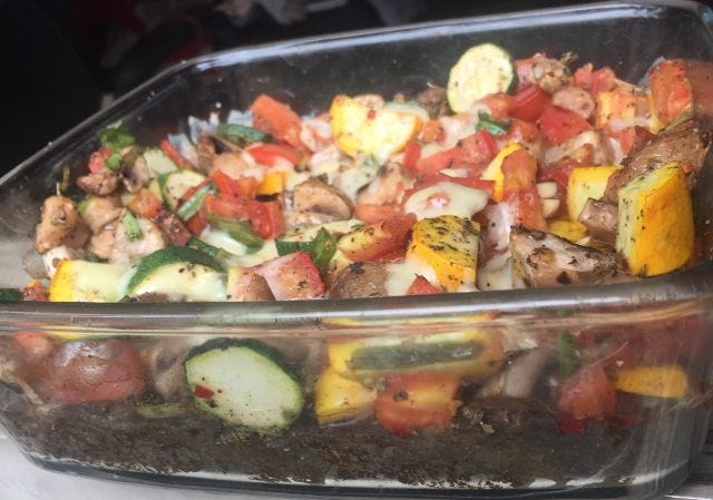 Side view of the bowl of pizza-bake with a huge mound of veggies on top of the crust. Side view of the bowl of pizza-bake with a huge mound of veggies on top of the crust.