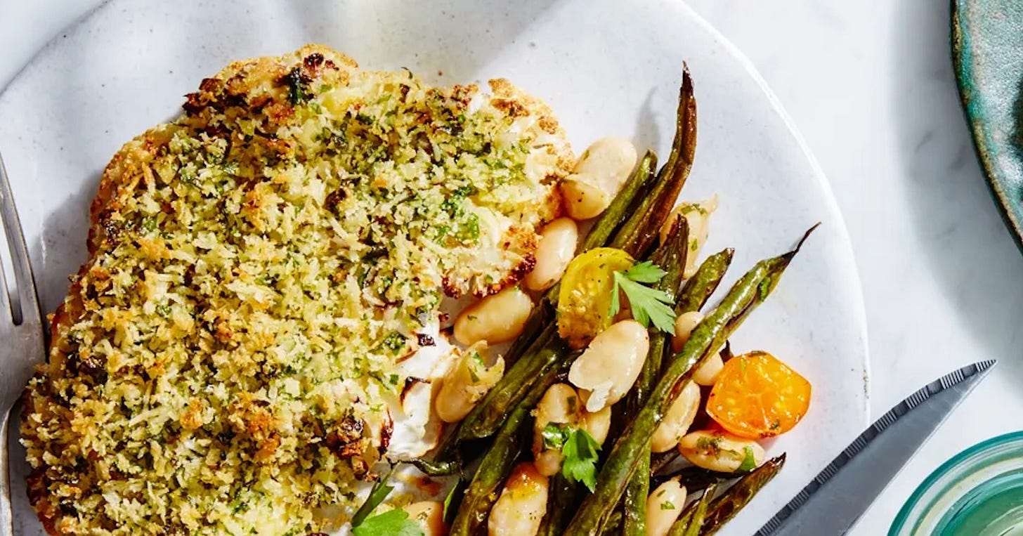 A delicious dish of herb-crusted cauliflower steaks with beans and tomatoes A delicious dish of herb-crusted cauliflower steaks with beans and tomatoes