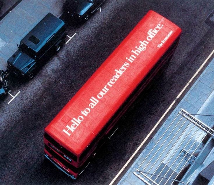 This may contain: a red bus is parked on the side of the road near other cars and trucks
