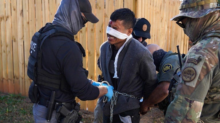 Innocent Americans are shown fleeing in the reflection of the gas mask of one of the administration's soldiers Innocent Americans are shown fleeing in the reflection of the gas mask of one of the administration's soldiers