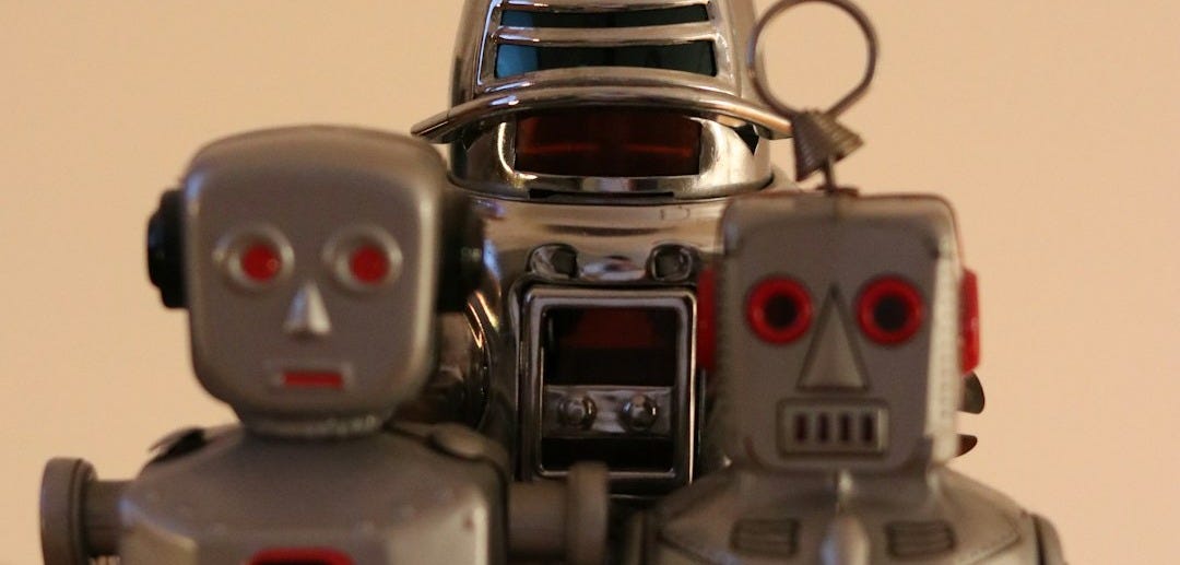 a couple of robot toys sitting on top of a wooden table