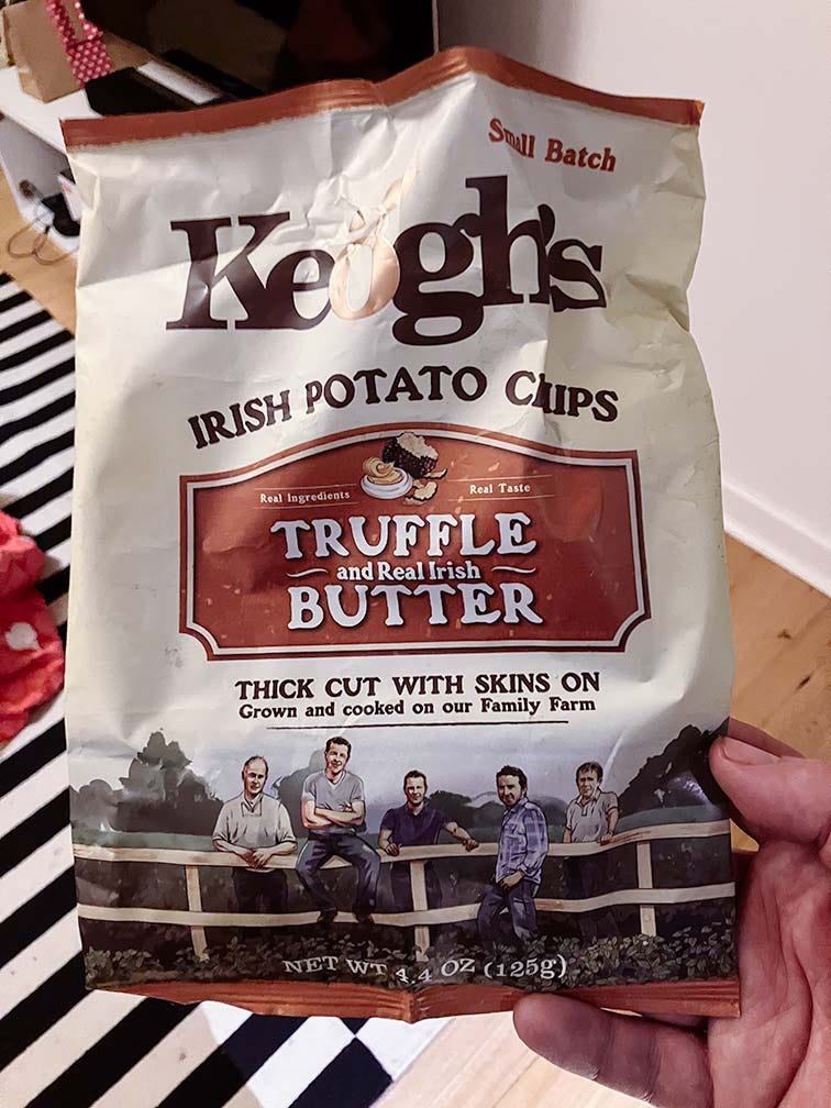 A hand holding a pack of Keogh's Truffle and real Irish butter potato chips