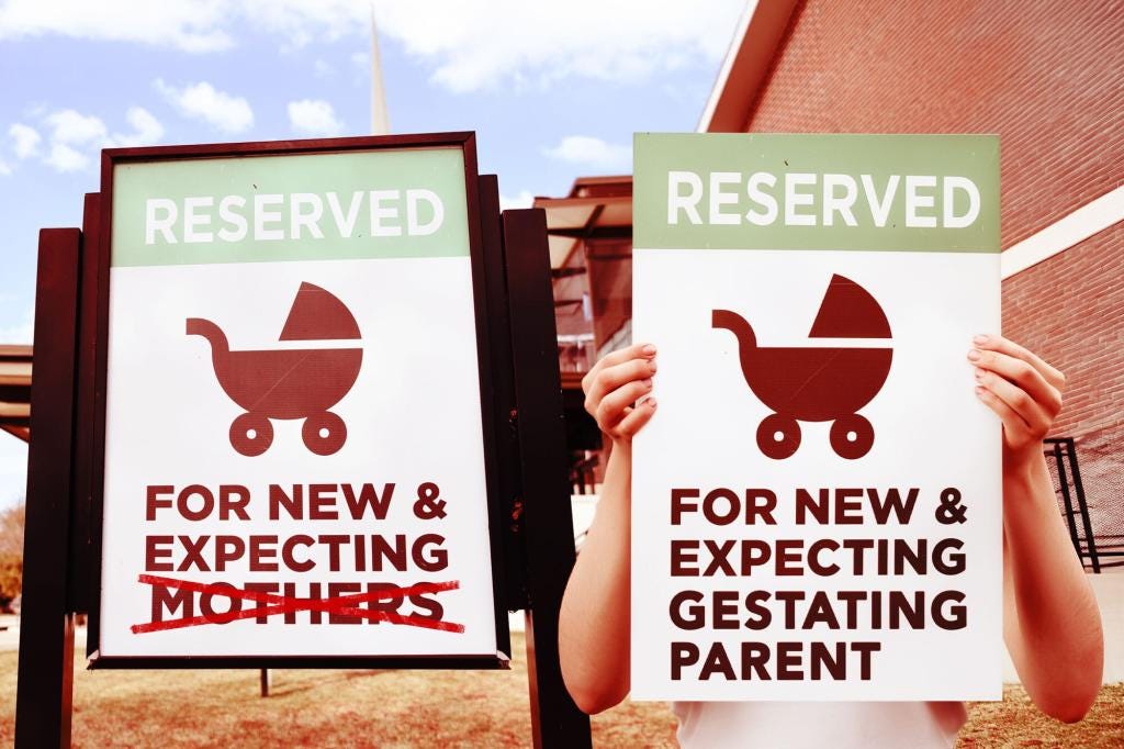 Two signs, one fixed and one held by hands, both with the word "RESERVED" and a baby carriage icon, but with different text below: the fixed sign reads "FOR NEW & EXPECTING MOTHERS" with "MOTHERS" crossed out, while the held sign reads "FOR NEW & EXPECTING GESTATING PARENT." Two signs, one fixed and one held by hands, both with the word "RESERVED" and a baby carriage icon, but with different text below: the fixed sign reads "FOR NEW & EXPECTING MOTHERS" with "MOTHERS" crossed out, while the held sign reads "FOR NEW & EXPECTING GESTATING PARENT."