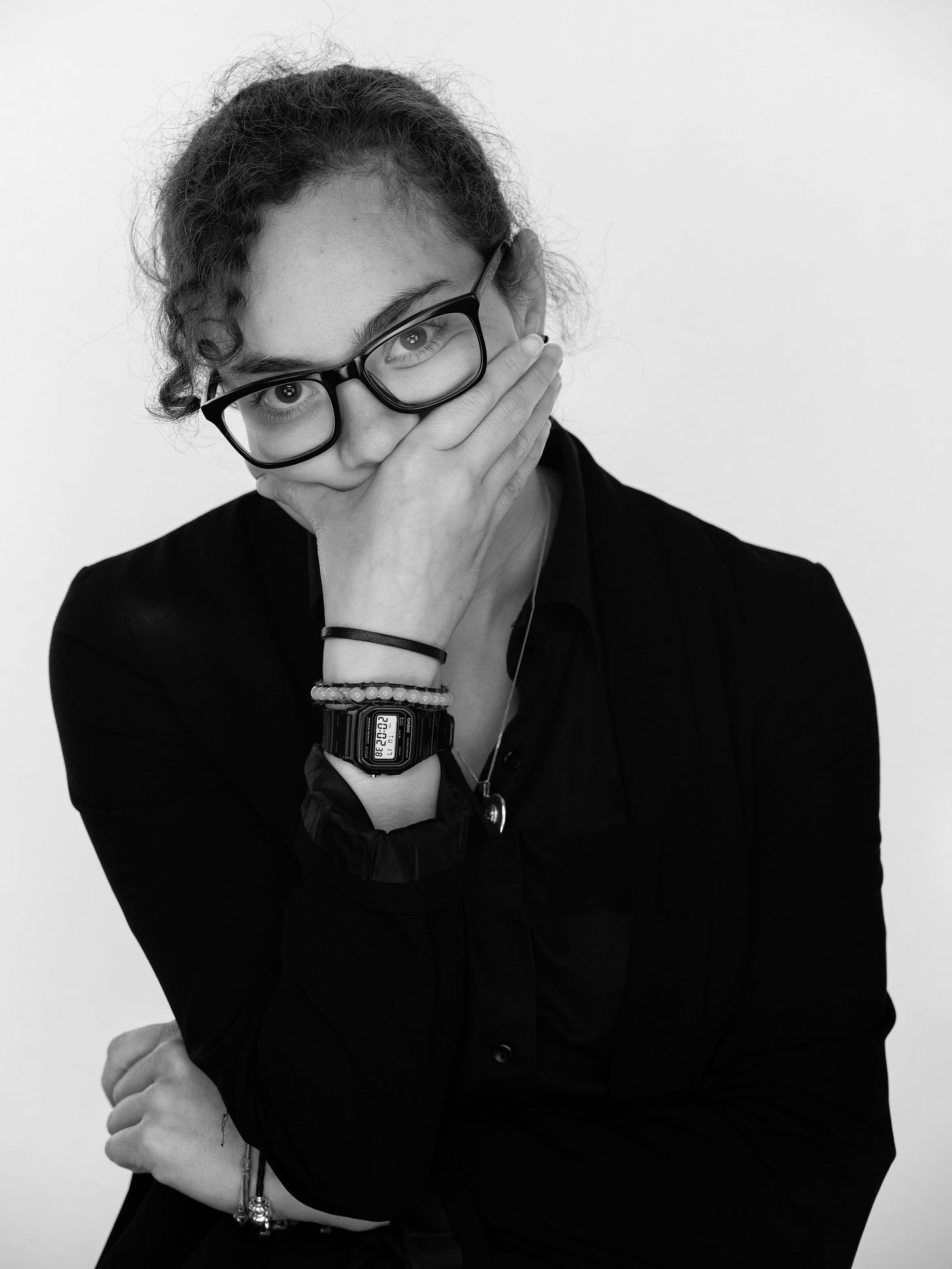 Business storytelling portrait | Professional skeptic in black blazer, glasses showing authentic personal brand | Marketing expert demonstrating persuasive body language with thought leadership pose | Trust-building personal branding photography for credible content strategy