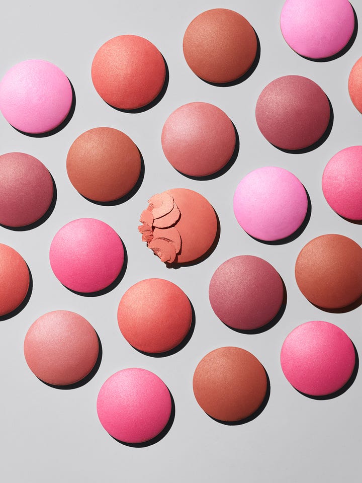 Two images: A makeup brush dipping into a blush compact; and round discs of blush scattered on a grey background.