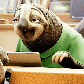 a sloth is wearing a green shirt and smiling while looking at a tablet