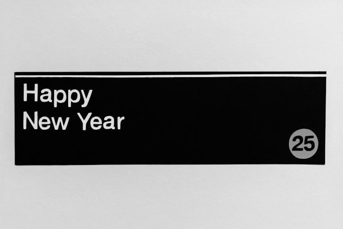 A sign that says happy new year hanging on a wall A sign that says happy new year hanging on a wall