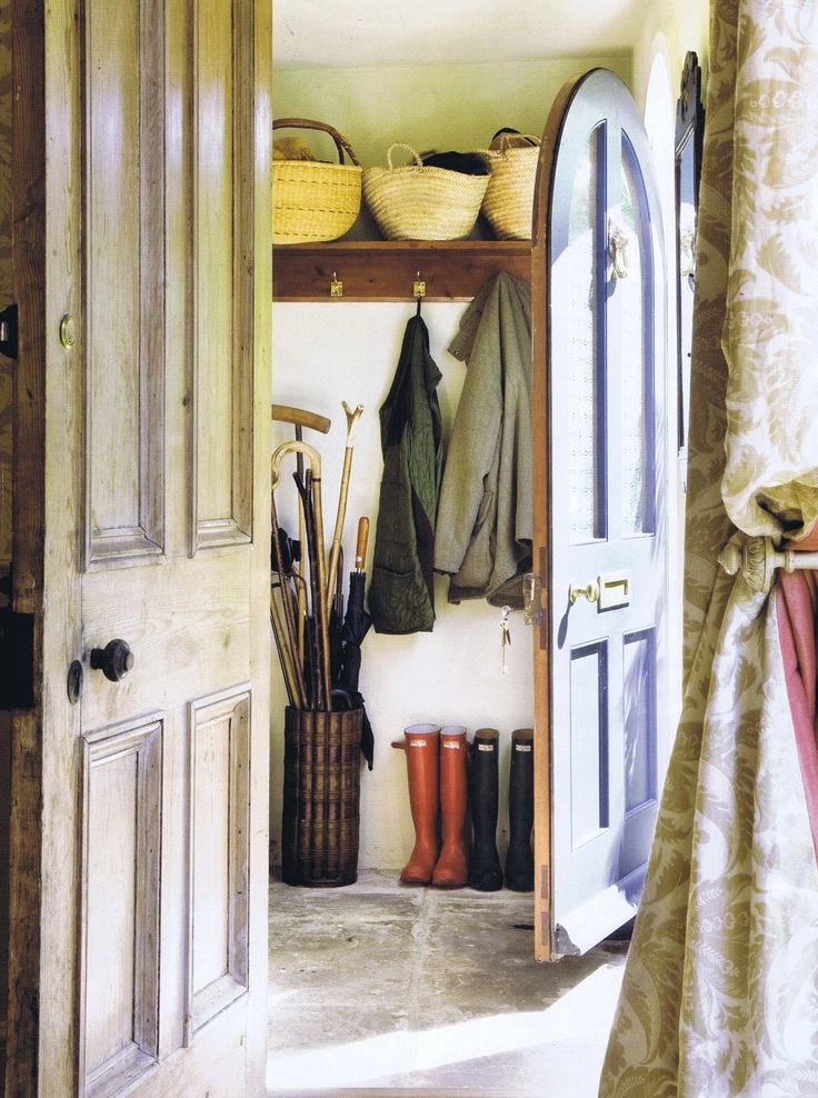This may contain: an open door leading into a room with boots and umbrellas on the shelf next to it