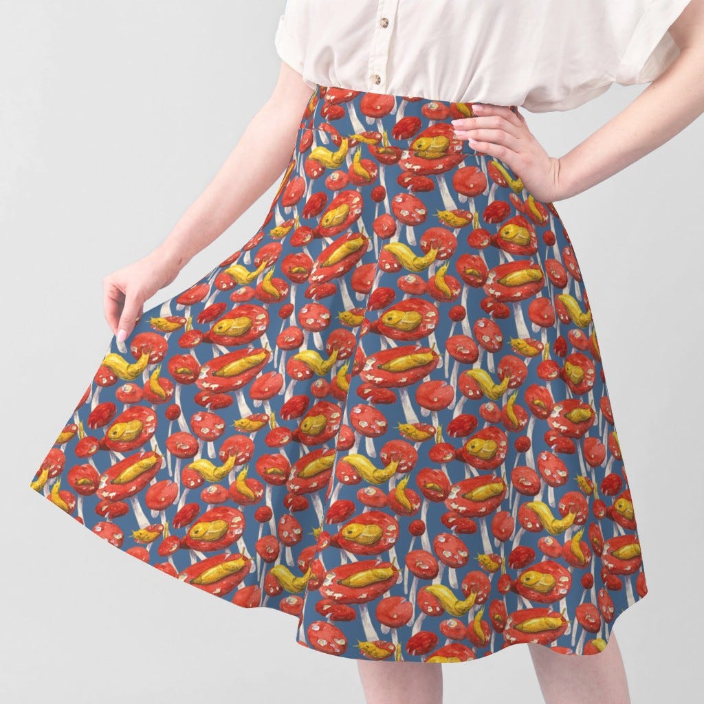 Spoonflower.com image of a skirt made using fabric with banana slugs on red mushroom caps over a blue background.