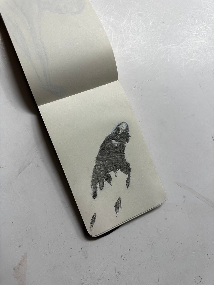 Photo of a drawing in my sketchpad done while waiting for a doctor’s appointment. The art features a rough rendering of a woman in dark robes with eyes closed and hands crossed on her chest.