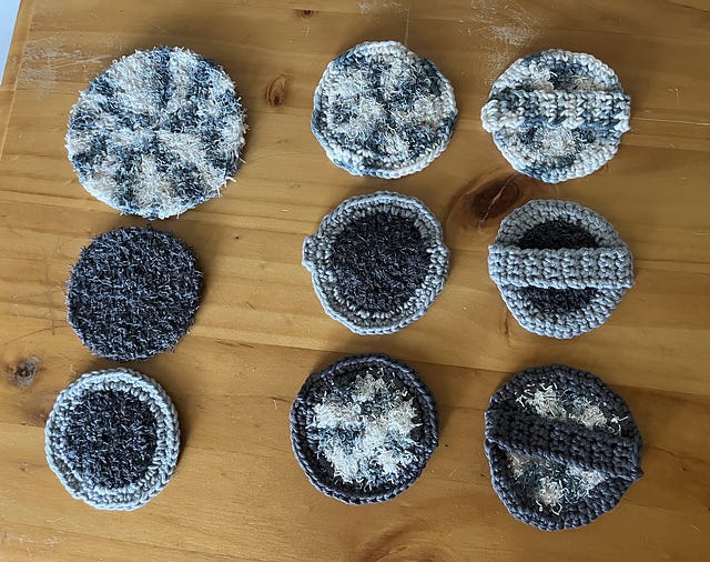 Photo of nine round scrubbies made in variegated grey yarn