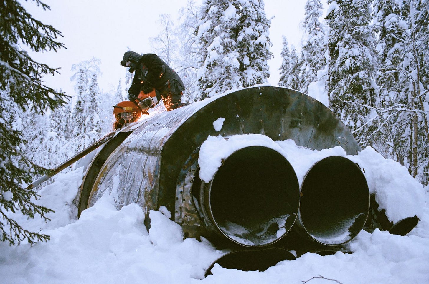 Man in snow gear on top of rocket booster