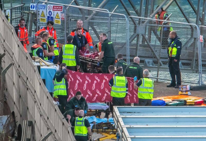 Paramedics attend to migrants picked up at sea in Dover on August 12, 2023. Six Afghan males died when a migrant boat heading to Britain sank in the Channel. AFP