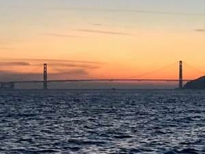 A bridge over water with a sunset in the background

AI-generated content may be incorrect.