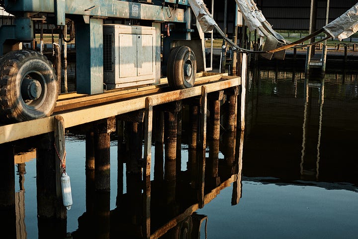 Yellow and blue-green color palette of water and a painted boat lift