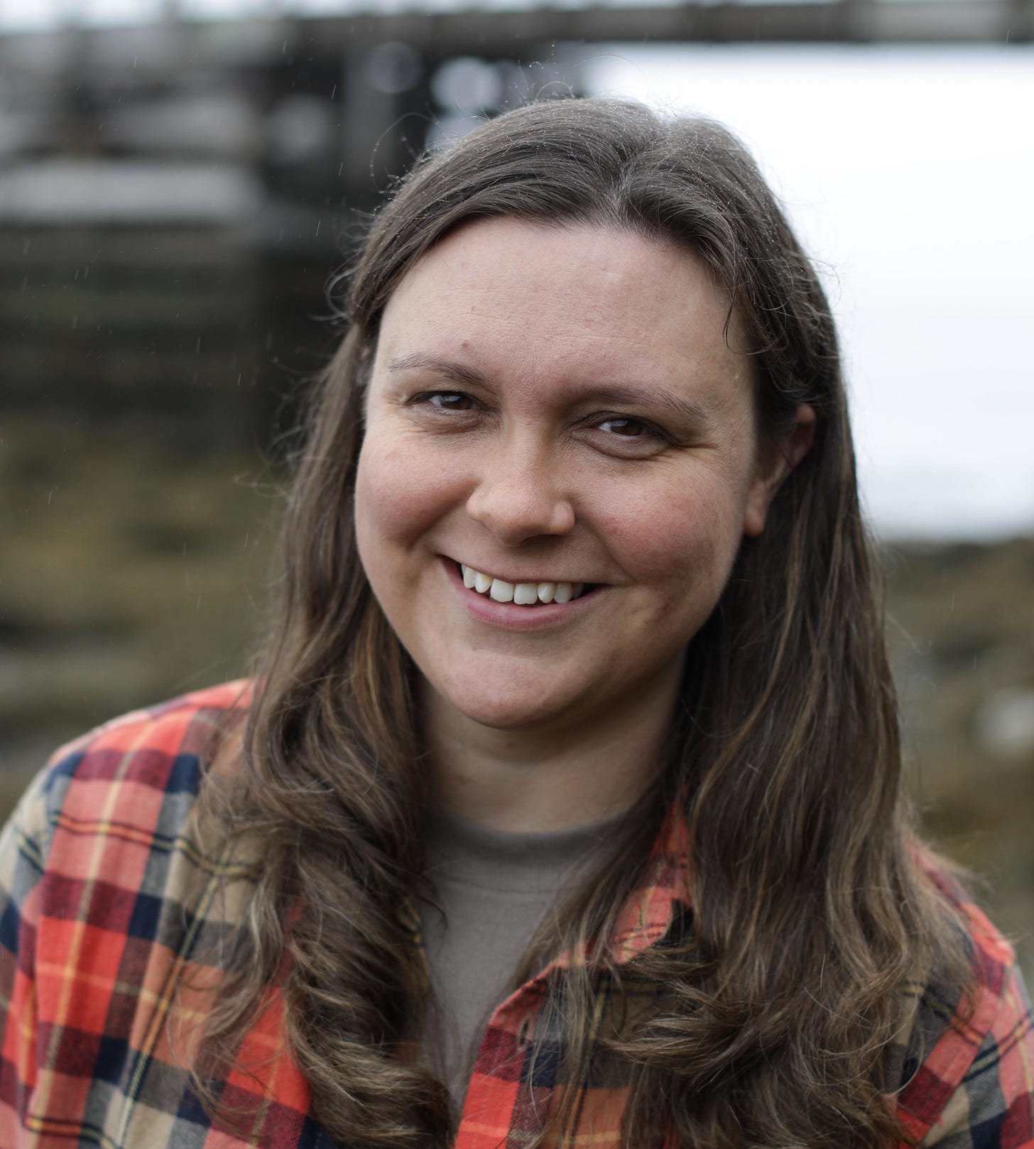 head and shoulders outdoor image of Andrea LaFlamme; youngish white woman, shoulder length brown hair, wearing flannel checked shirt head and shoulders outdoor image of Andrea LaFlamme; youngish white woman, shoulder length brown hair, wearing flannel checked shirt