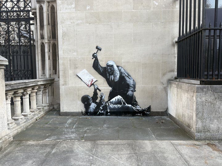 A new artwork by Banksy which shows a judge attacking a protester with a gavel at the Royal Courts of Justice in London.