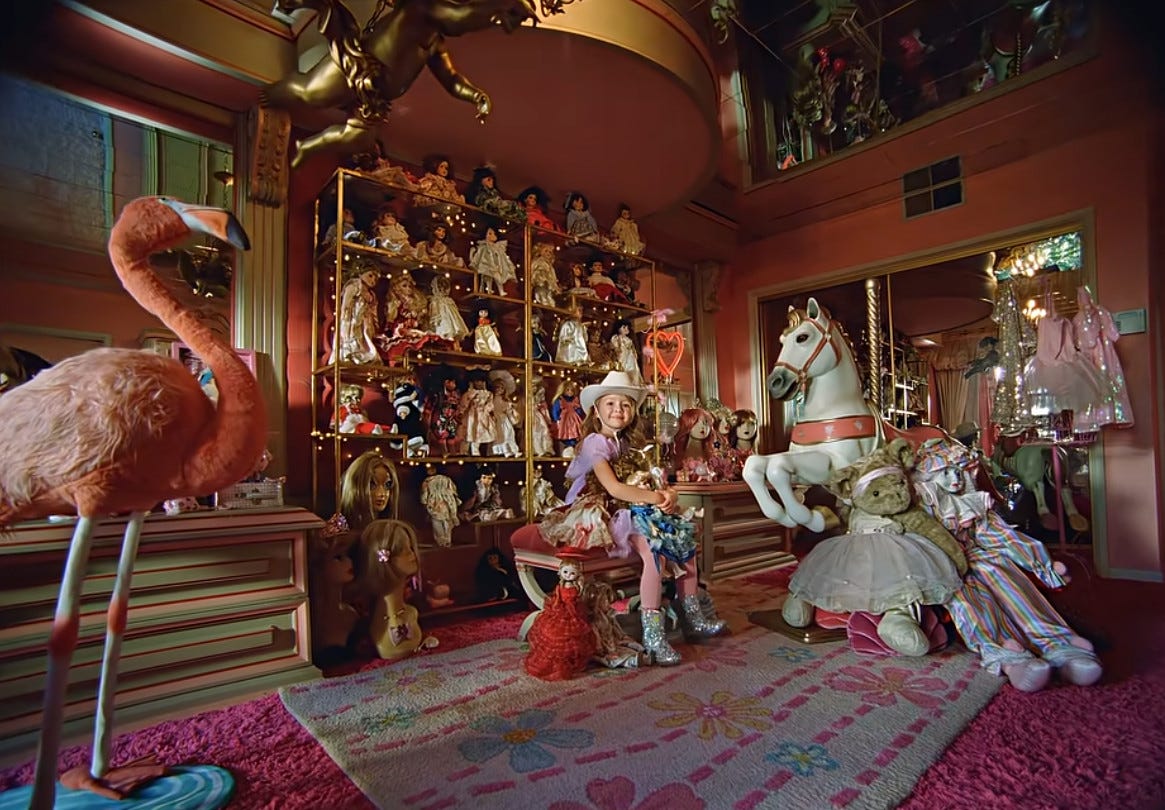 Girl surrounded by dozens of expensive dolls and other toys Girl surrounded by dozens of expensive dolls and other toys