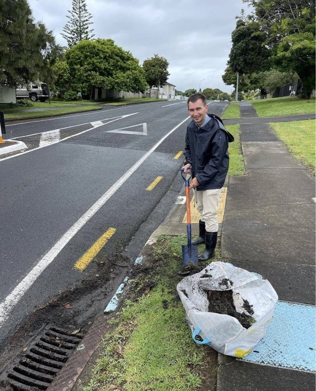 Simeon Brown with a bag of dirt on a street unaffected by flooding.