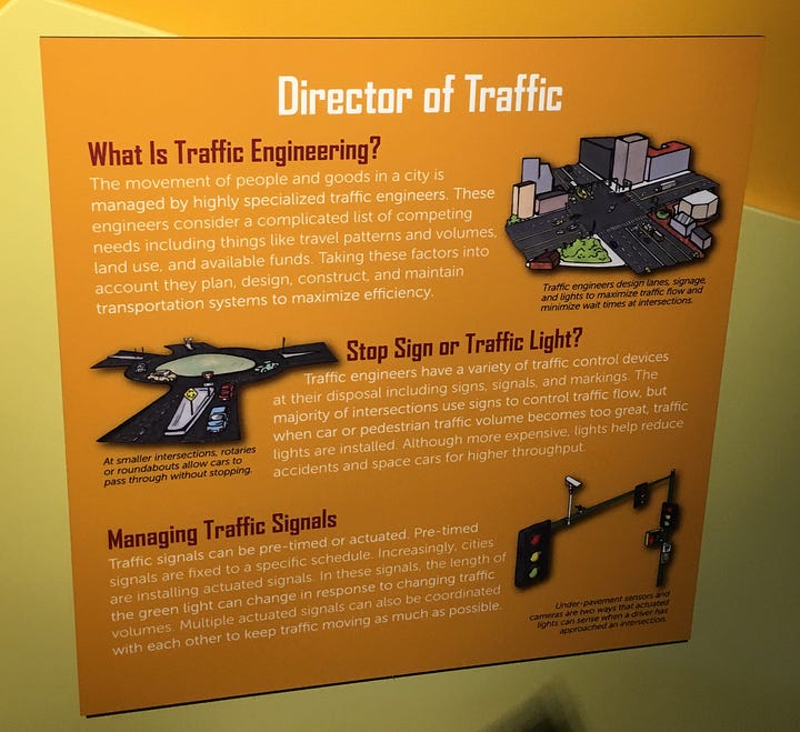 Photos of four signs from the City Science exhibit that give deeper context to exhibit interactives: Neighborhood Design; Director of Traffic (about traffic engineering), City Hot Zones (what causes urban heat islands), and Best Nest (discusses the impact of landscape change on bird biodiversity).