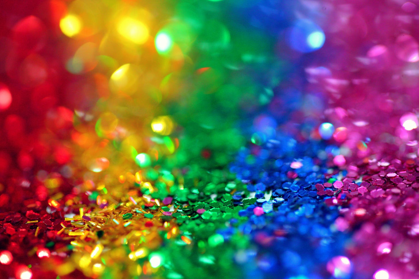 A display of assorted glitter colors that together make a rainbow.
