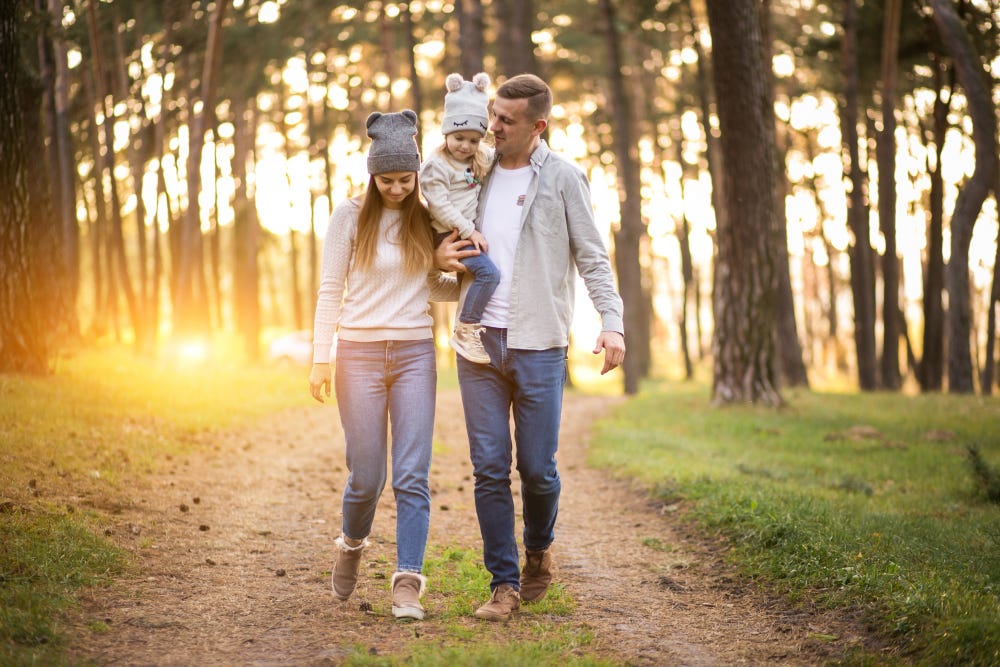 Young family walking in the woods.