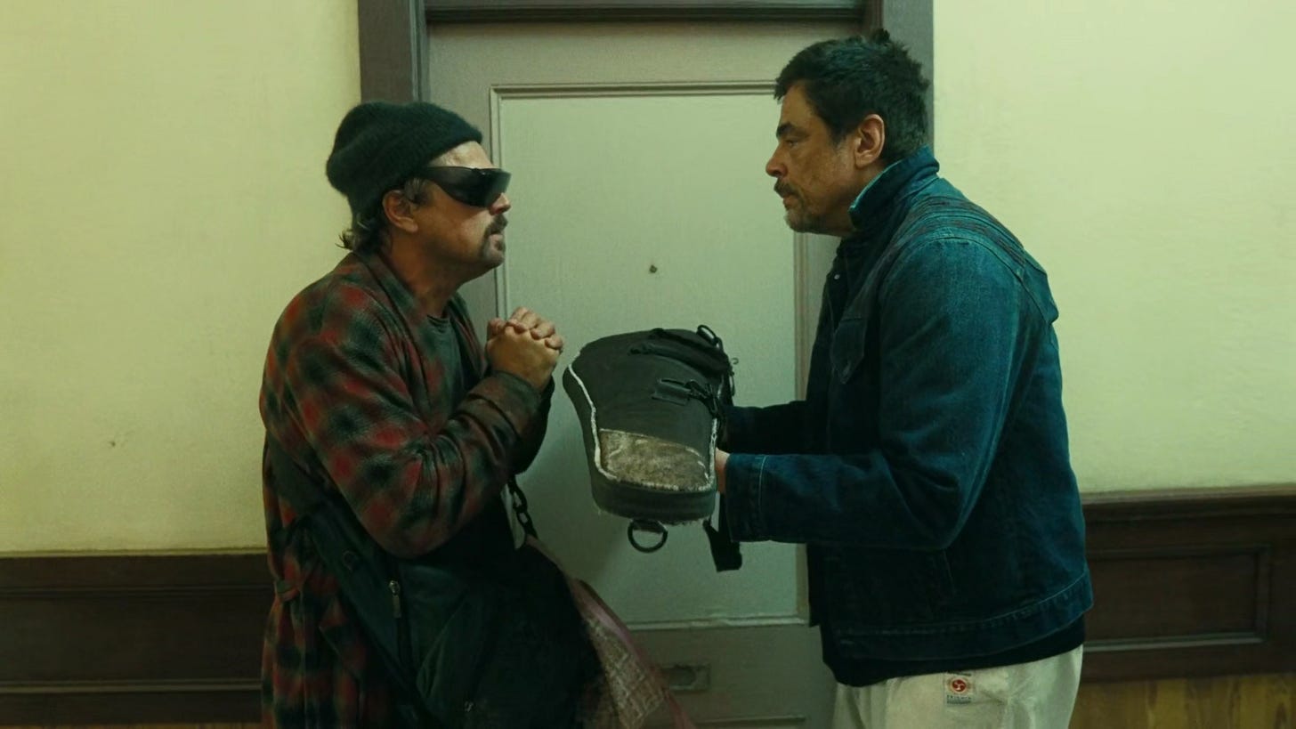 Bob pleads with Sensei in hallway who holds a rifle out in a violin case