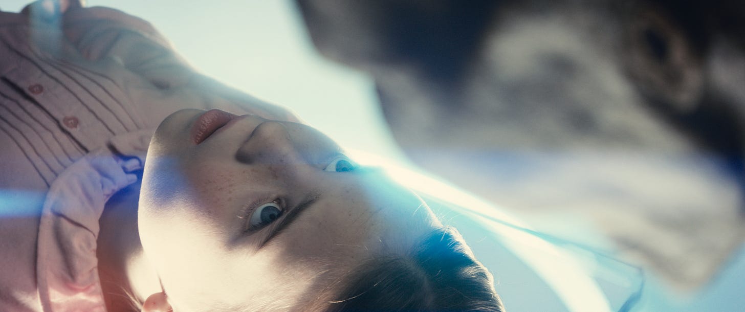 An alien stands over a young girl in Disclosure Day. An alien stands over a young girl in Disclosure Day.