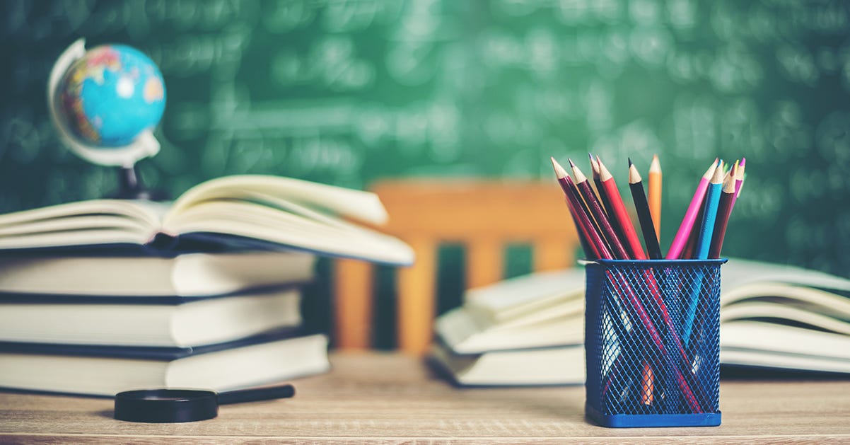 Imagem de uma mesa escolar contendo material de estudo, como lápis e livros empilhados uns sobre os outros, além de um pequeno mapa mundi Imagem de uma mesa escolar contendo material de estudo, como lápis e livros empilhados uns sobre os outros, além de um pequeno mapa mundi