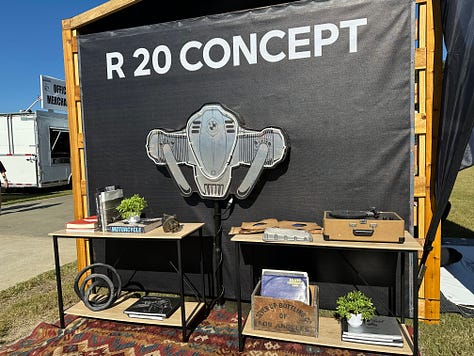 an artist doing a large live sketch of a concept bike; the race track; vintage bikes, and a cigar