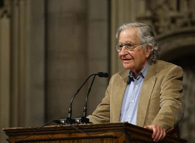 an older man wearing glasses stands at a lectern an older man wearing glasses stands at a lectern