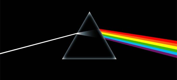 This may contain: the dark side of the moon is shown with a rainbow light coming out of it