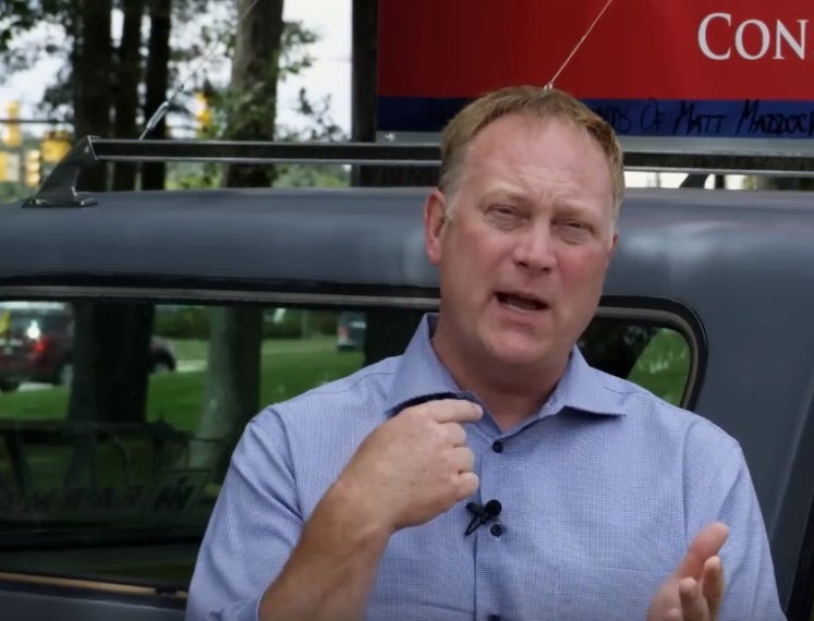 Rep. Matt Maddock in front of a SUV in a park, wearing a blue shirt and gesturing toward himself. Rep. Matt Maddock in front of a SUV in a park, wearing a blue shirt and gesturing toward himself.