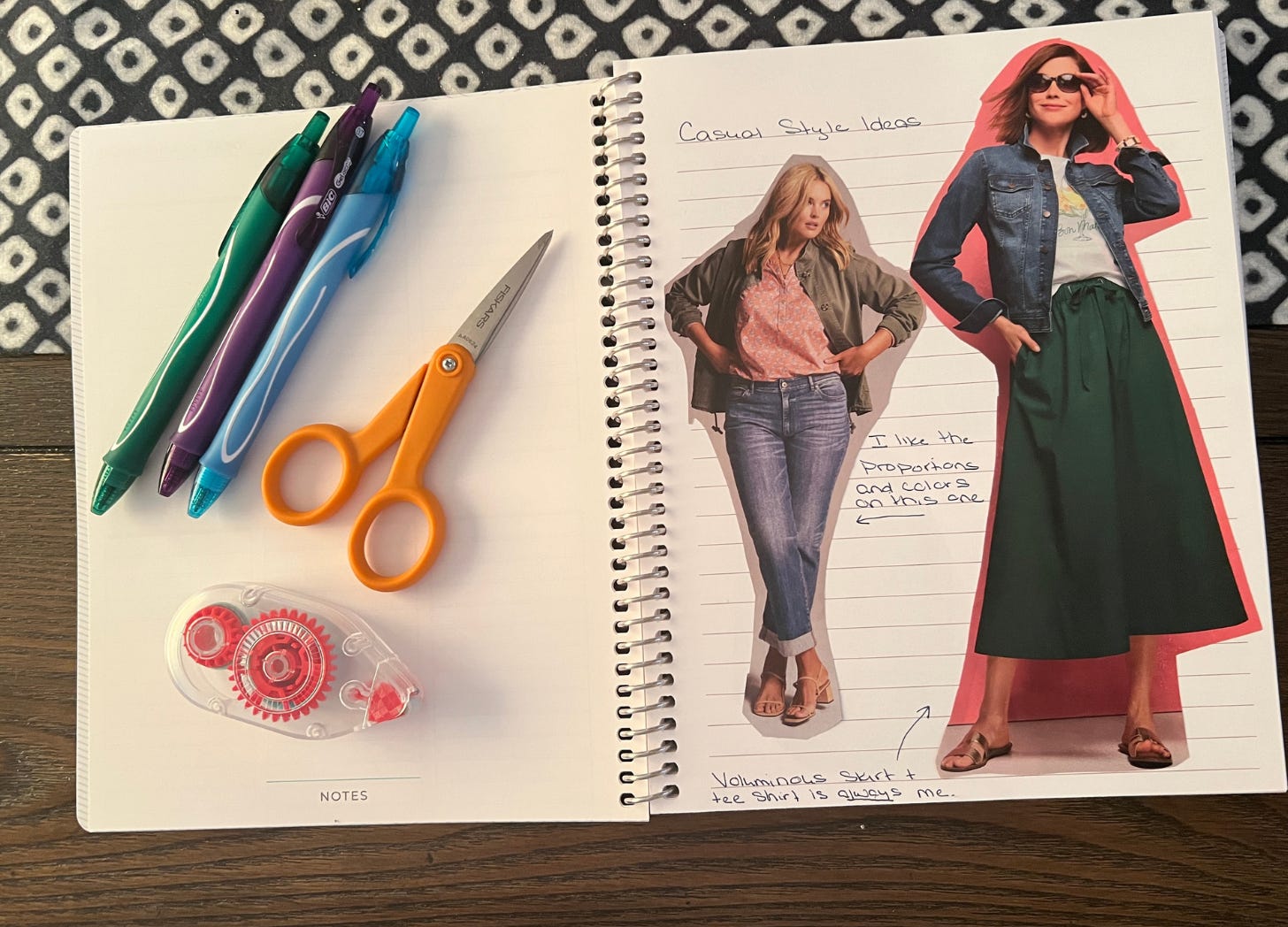 A notebook with colorful pens, scissors and glue appears with two images cut from a clothing catalog. 