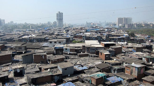 Des taudis à perte de vue constituent le bidonville. Au loin, on aperçoit les gratte-ciels de Bombay Des taudis à perte de vue constituent le bidonville. Au loin, on aperçoit les gratte-ciels de Bombay