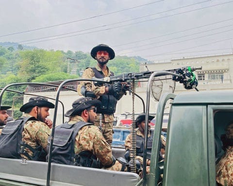 Soldiers patrol near the site of the damaged mosque in Muzaffarabad. Soldiers patrol near the site of the damaged mosque in Muzaffarabad.