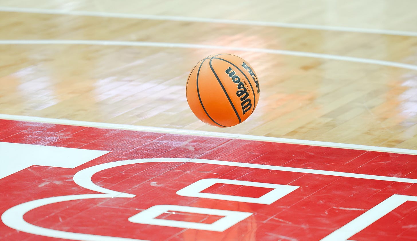 Wisconsin Badgers basketball sitting on the Kohl Center court floor.