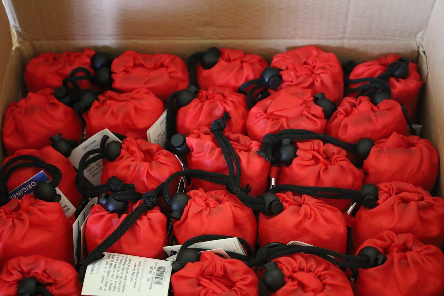 A bunch of red reusable bags